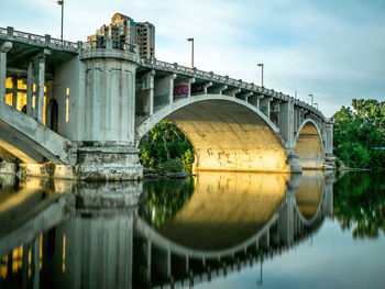 Arch bridge over river against sky