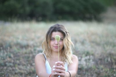 Close-up of a beautiful young woman holding flower