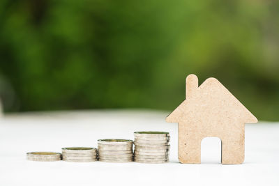 Stack of coins with house on table