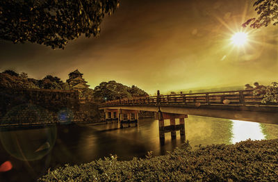 Bridge over river against sky during sunset