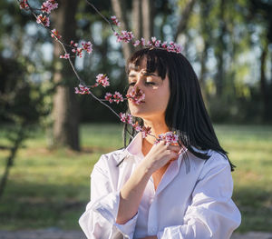 Woman standing by flowering plant