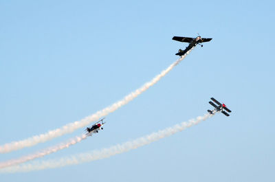 Low angle view of airshow against sky