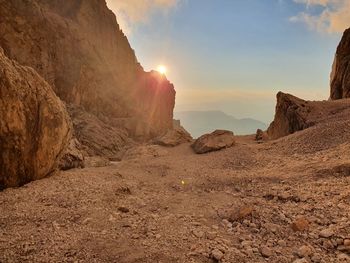 Rock formations on landscape against sky during sunset