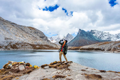 Man standing on snowcapped mountain against sky