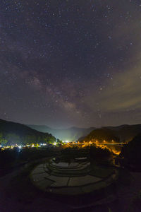 Scenic view of illuminated mountains against sky at night