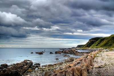 Scenic view of beach against storm clouds