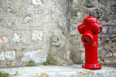 Red fire hydrant against wall
