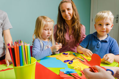 Portrait of mother and kids doing craft at home