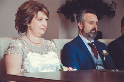 Mature bride and bridegroom sitting at table