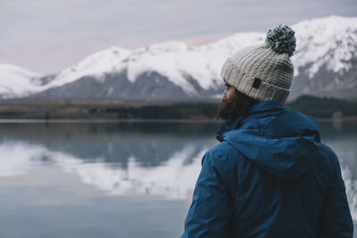 Young woman looking at the southern alps reflection over lake tekapo