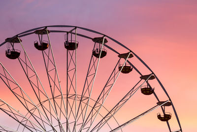 Low angle view of ferris wheel against sky at sunset