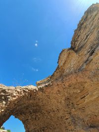 Low angle view of rock formations against blue sky