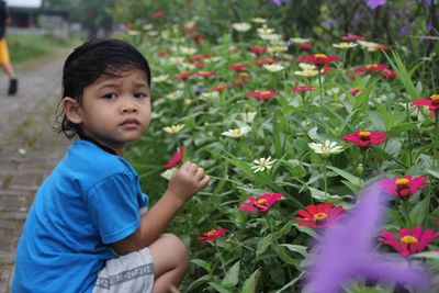Boy standing on flowering plant