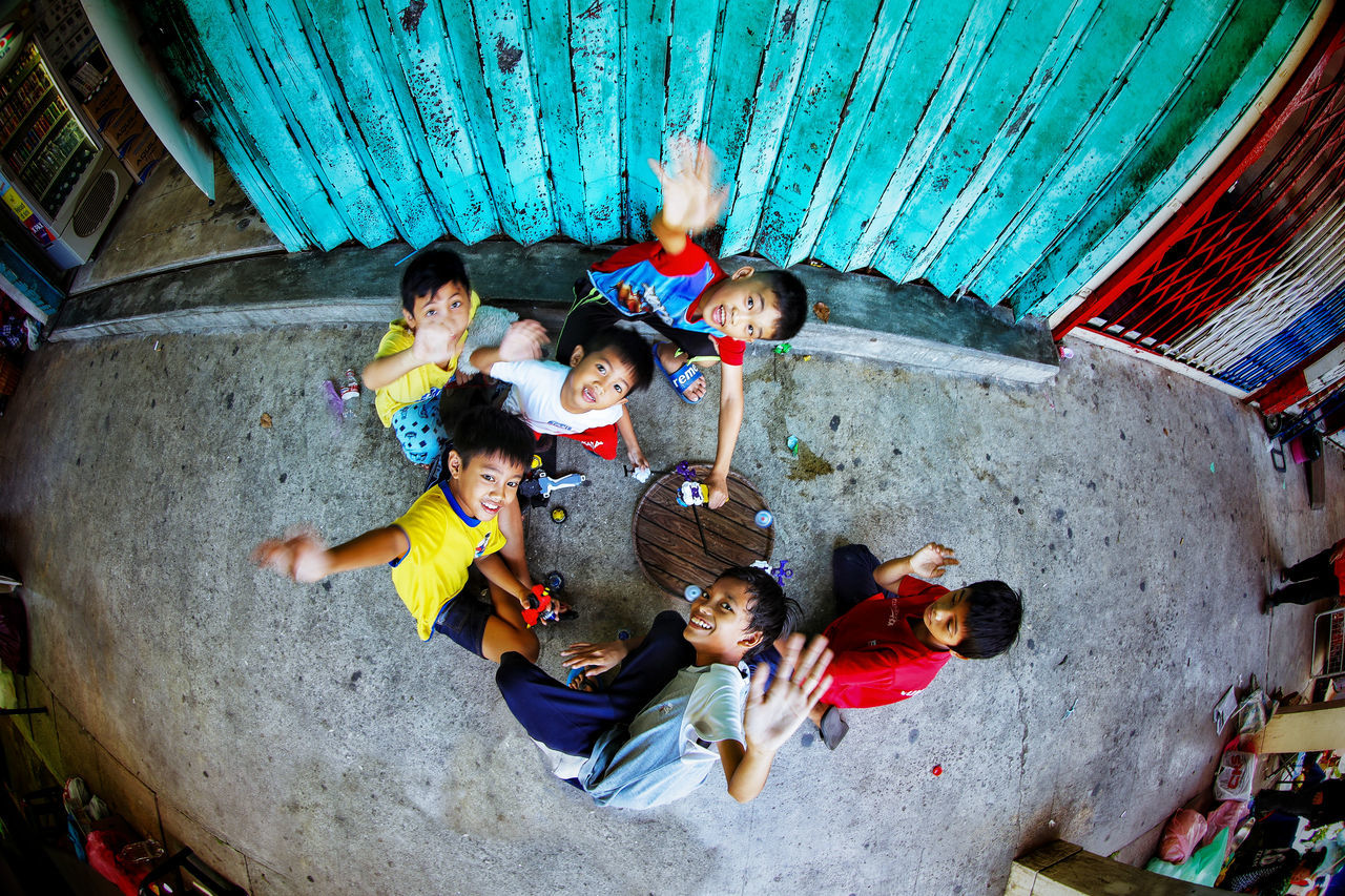 group of people, high angle view, men, males, women, adult, togetherness, child, group, portrait, boys, real people, girls, people, females, young adult, childhood, looking at camera, medium group of people, indoors