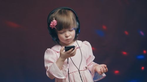 Girl listening music against black background