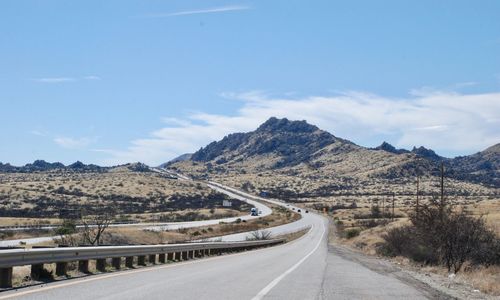 Empty road along landscape and mountains against sky