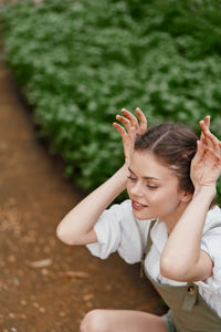 Side view of woman sitting on field