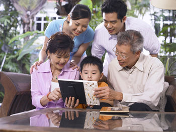 Smiling family looking picture frame at back yard