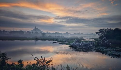 Scenic view of lake against sky during sunrise