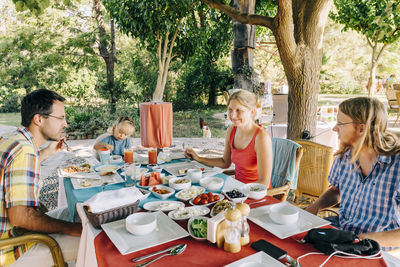 Family having meal at table in yard