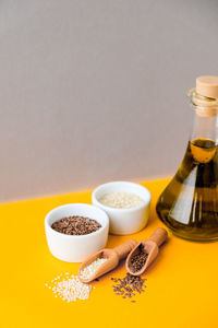 Sesame and flax seeds wooden spoons with oil in glass bottle. healthy food concept. vegan keto diet. 