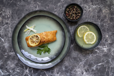 Directly above shot top view of salmon fish fillet cooked with different spices and served on plate.