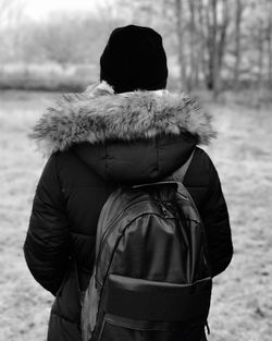 Rear view of person standing on field during winter