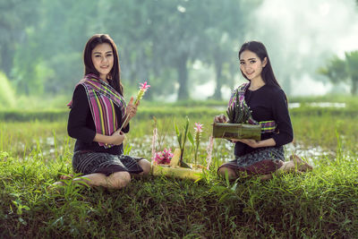 Portrait of smiling young woman sitting on grass