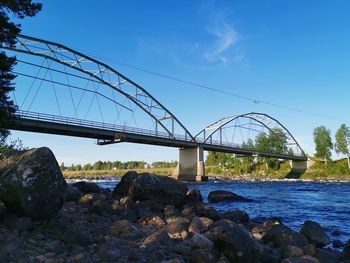 Bridge over calm sea against blue sky