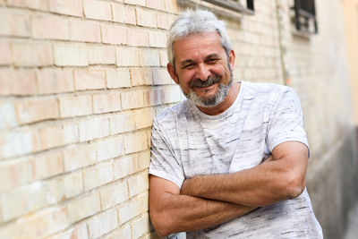 Portrait of smiling man standing against wall