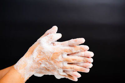 Close-up of hand against black background