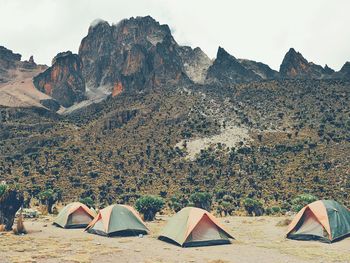 Tents against rocky mountains