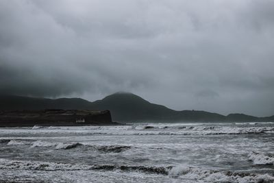 Scenic view of sea against storm clouds