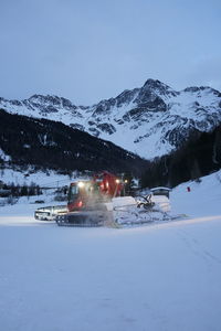 Cars on snow covered mountain against sky