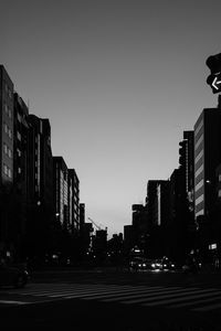 City street and buildings against sky at dusk