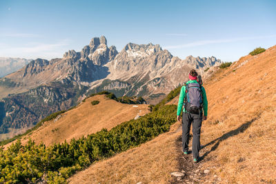 Rear view of man on mountain against sky