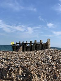 Stone wall by sea against sky