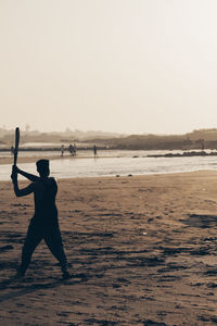 Silhouette man on beach against clear sky