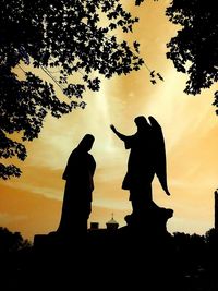 Low angle view of silhouette statue against sky