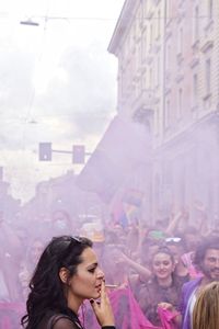 Young woman with arms raised in city