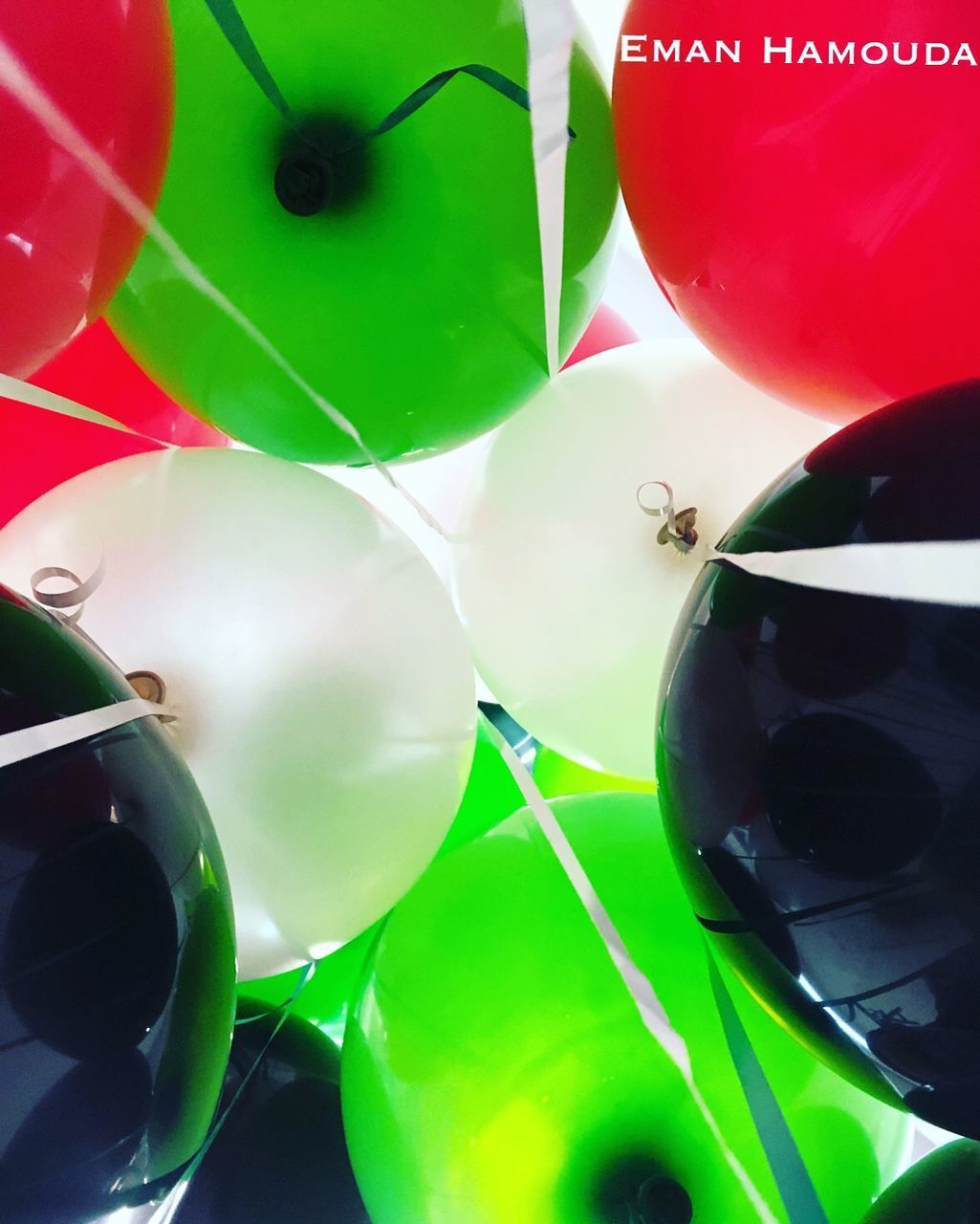 HIGH ANGLE VIEW OF MULTI COLORED BALLOONS IN GREEN BACKGROUND