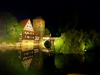 Reflection of illuminated building in water at night