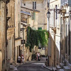 People walking on street amidst buildings in city