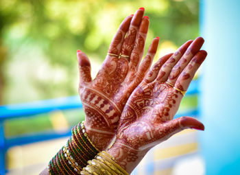 Cropped hands of woman showing henna tattoo