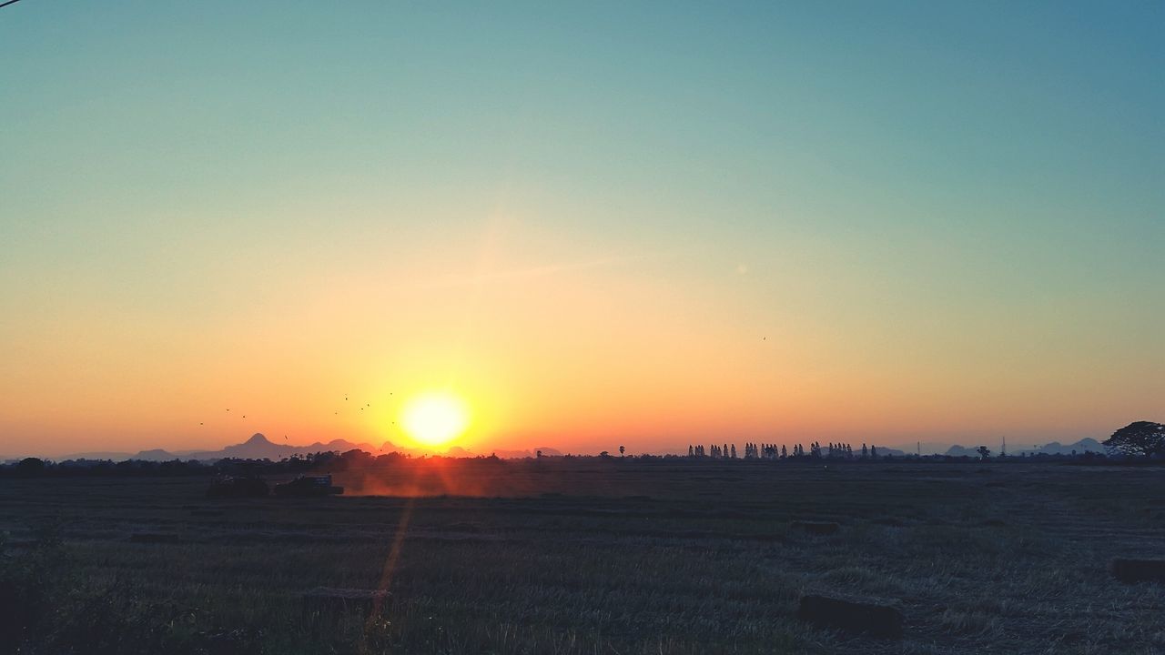 sunset, sun, copy space, orange color, clear sky, landscape, tranquil scene, scenics, tranquility, sunlight, beauty in nature, nature, field, built structure, silhouette, sky, idyllic, sunbeam, horizon over land, outdoors