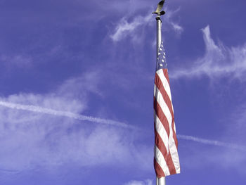 Low angle view of flag against blue sky