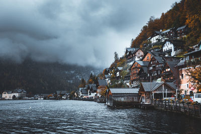 Scenic view of river by buildings against sky