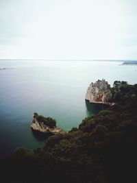 Scenic view of cliff by sea against sky