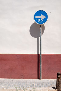 Road sign against wall