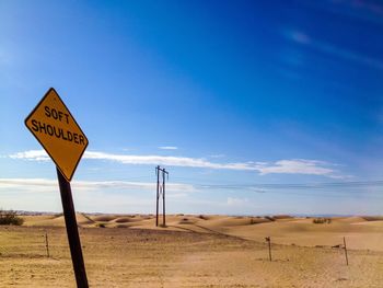 Road sign against clear blue sky